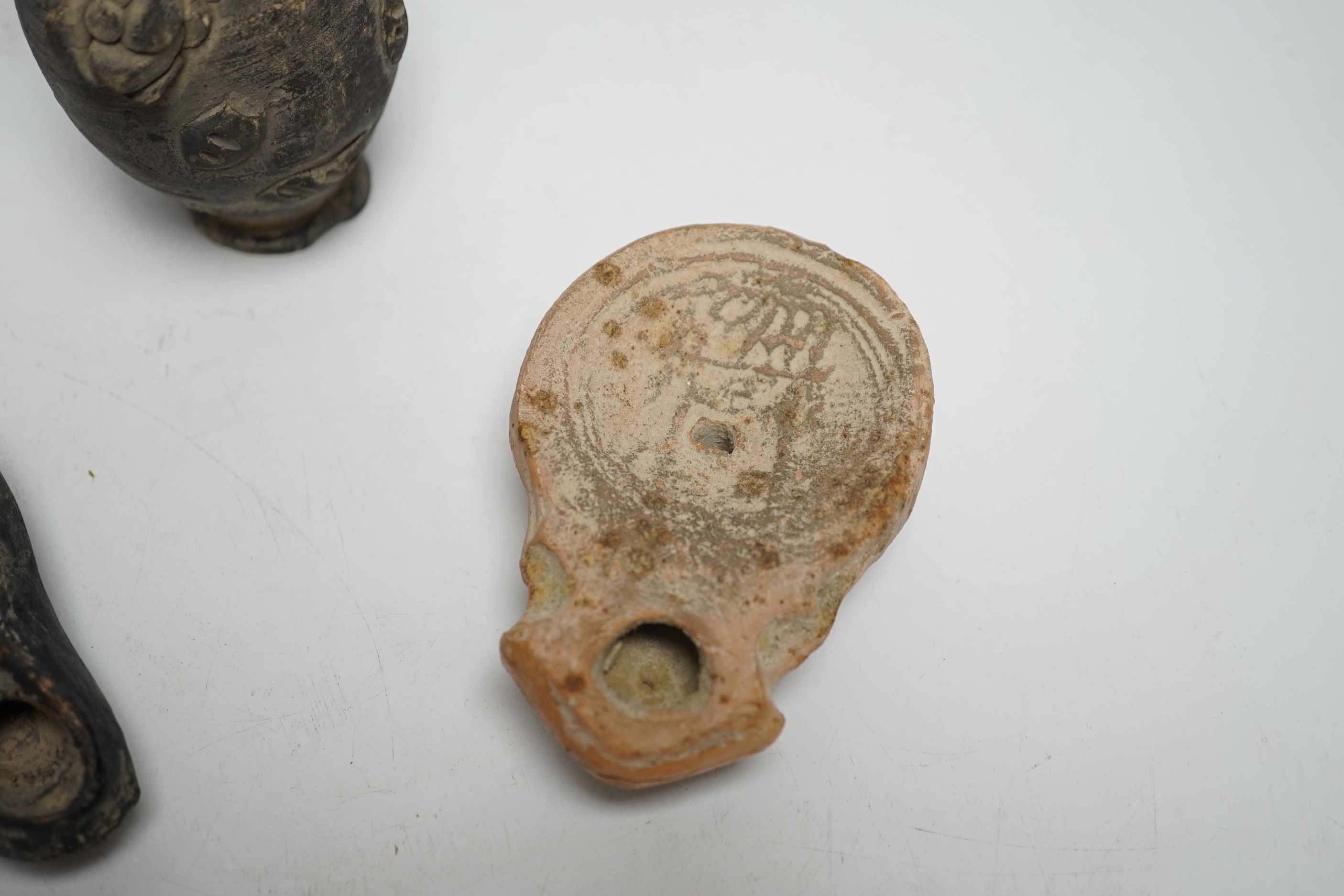 Two Roman oil lamps and an early ewer, tallest 14.5cm